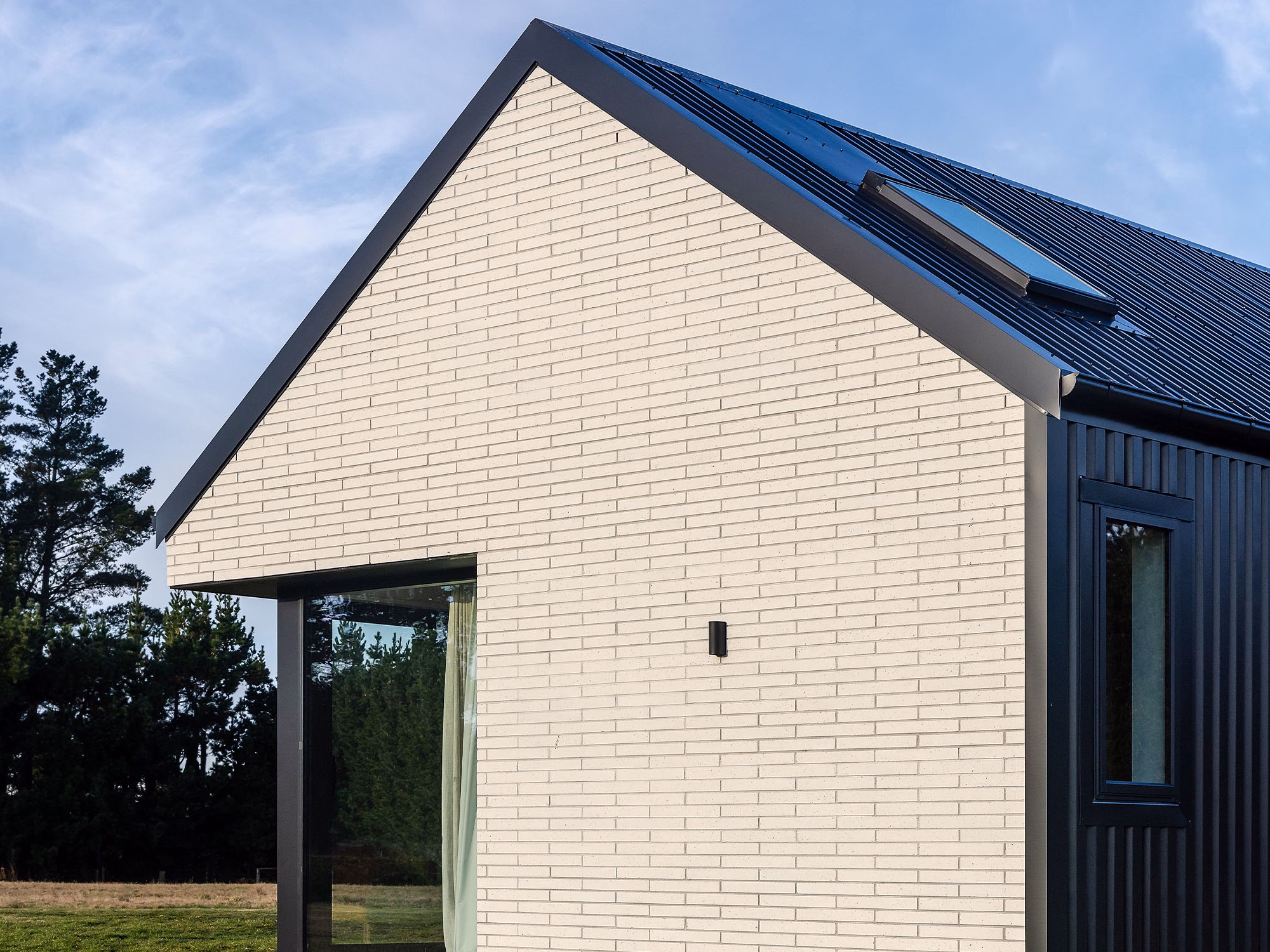 Open plan living area at Te Mata House with masonry fireplace, 4.3‑metre stud and polished concrete floor